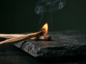Two matches close together, one lit, symbolizing how conversations can suddenly ignite into conflict.